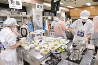 京都府代表の調理台でたくさんのお皿に盛付けをしている2名の参加者の写真