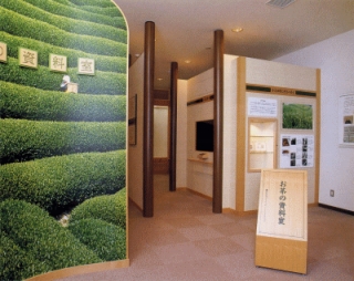 茶畑の風景の写真に郷土資料室と書かれた案内板がある郷土資料室前を写した写真