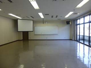 左前にスクリーン、正面にホワイトボードがあり、広々とした研修室3の室内写真