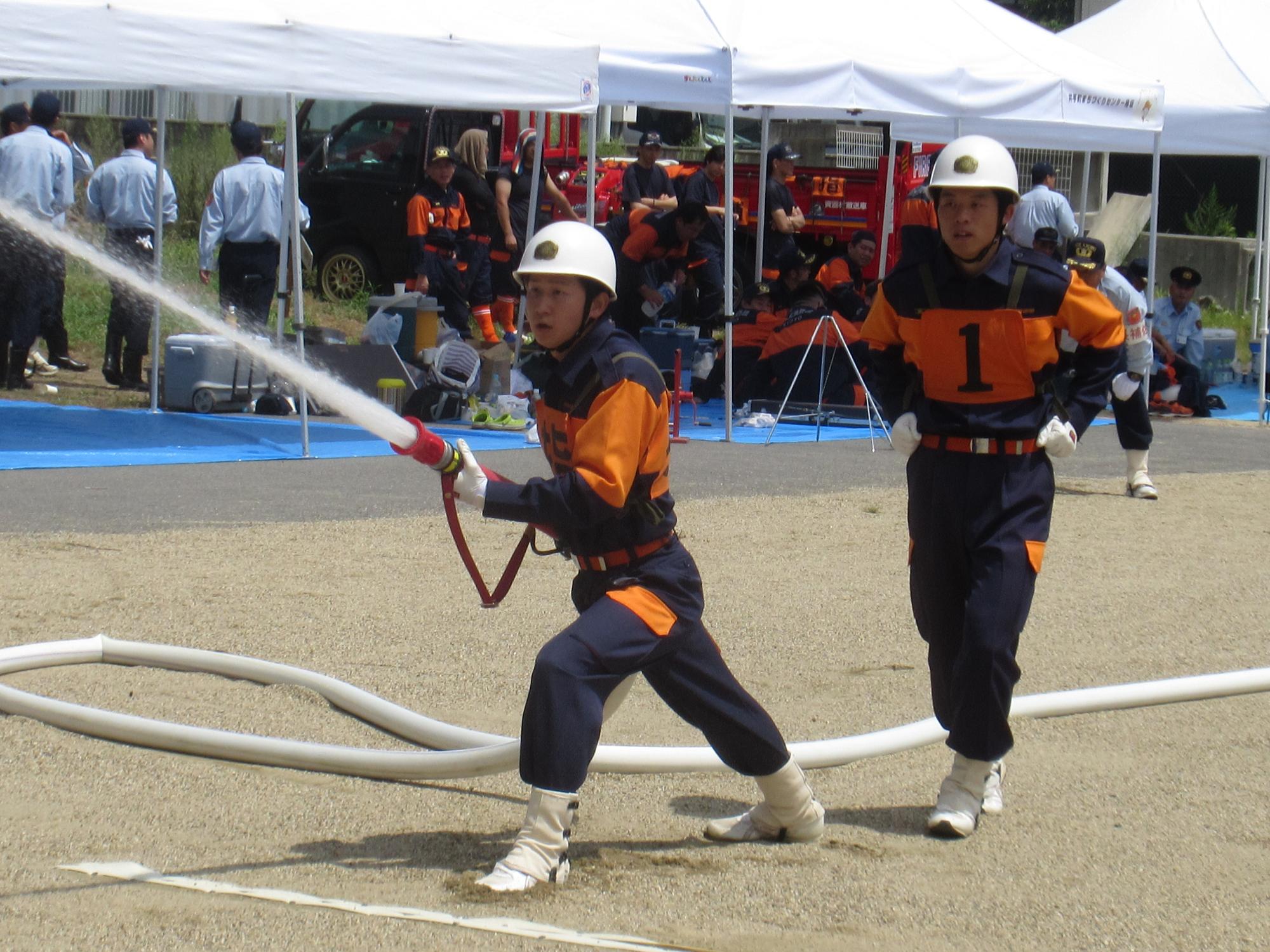 小型ポンプ操法を披露している第1分団第5部（銘城台支部）の選手たちの写真