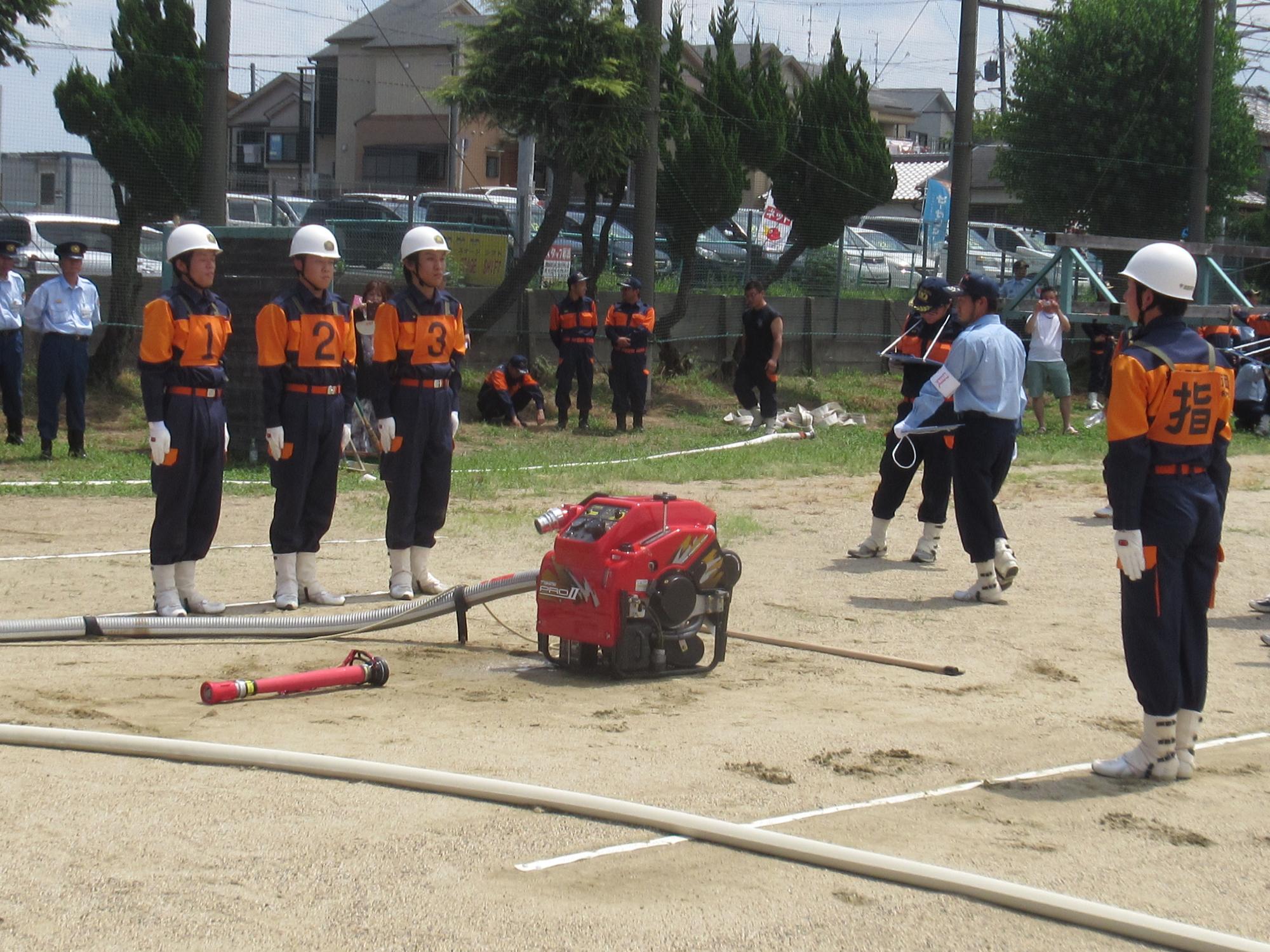 小型ポンプ操法を披露している第1分団第5部（銘城台支部）の選手たちの写真