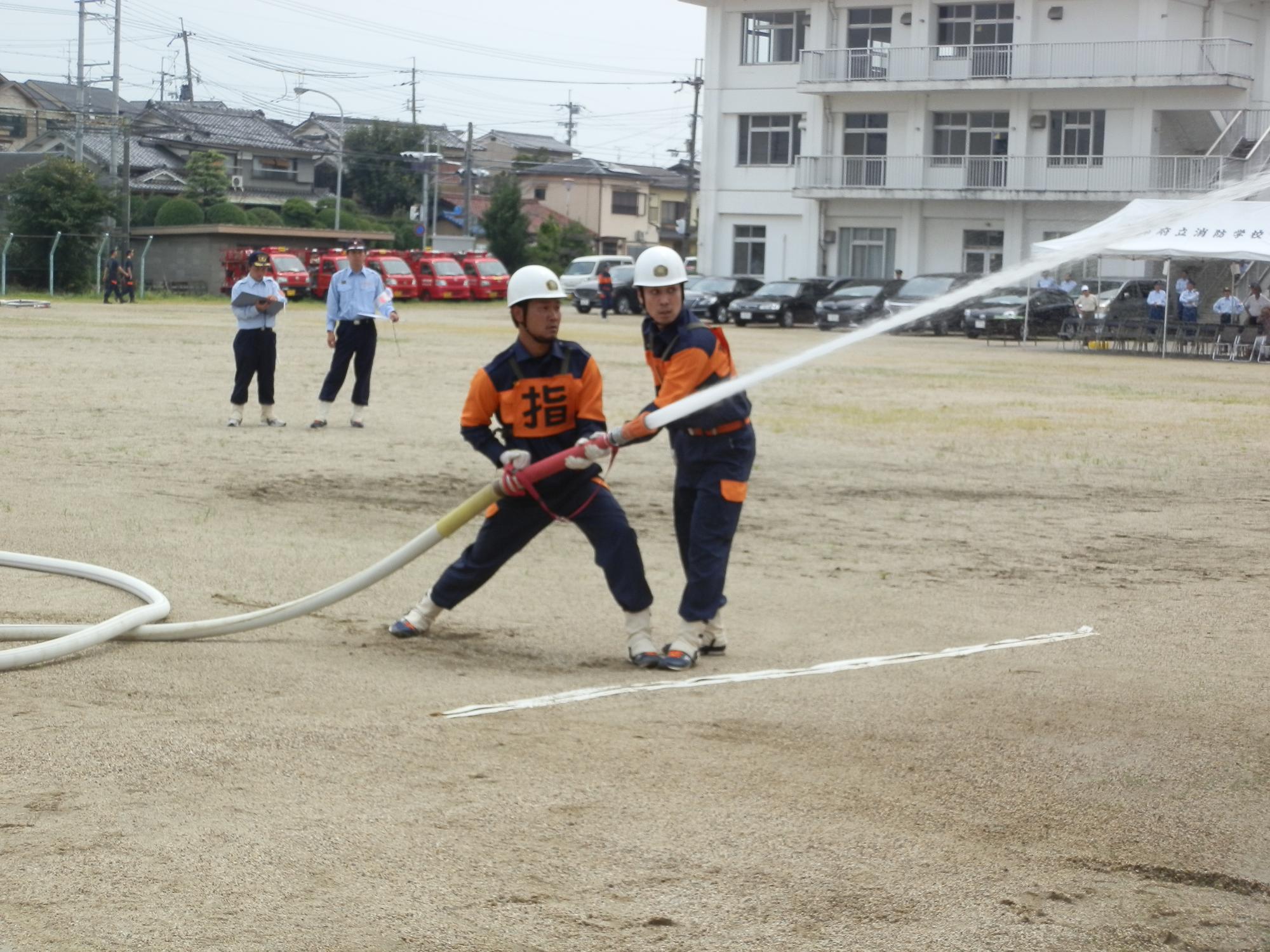 小型ポンプ操法を披露している第2分団選抜の選手たちの写真