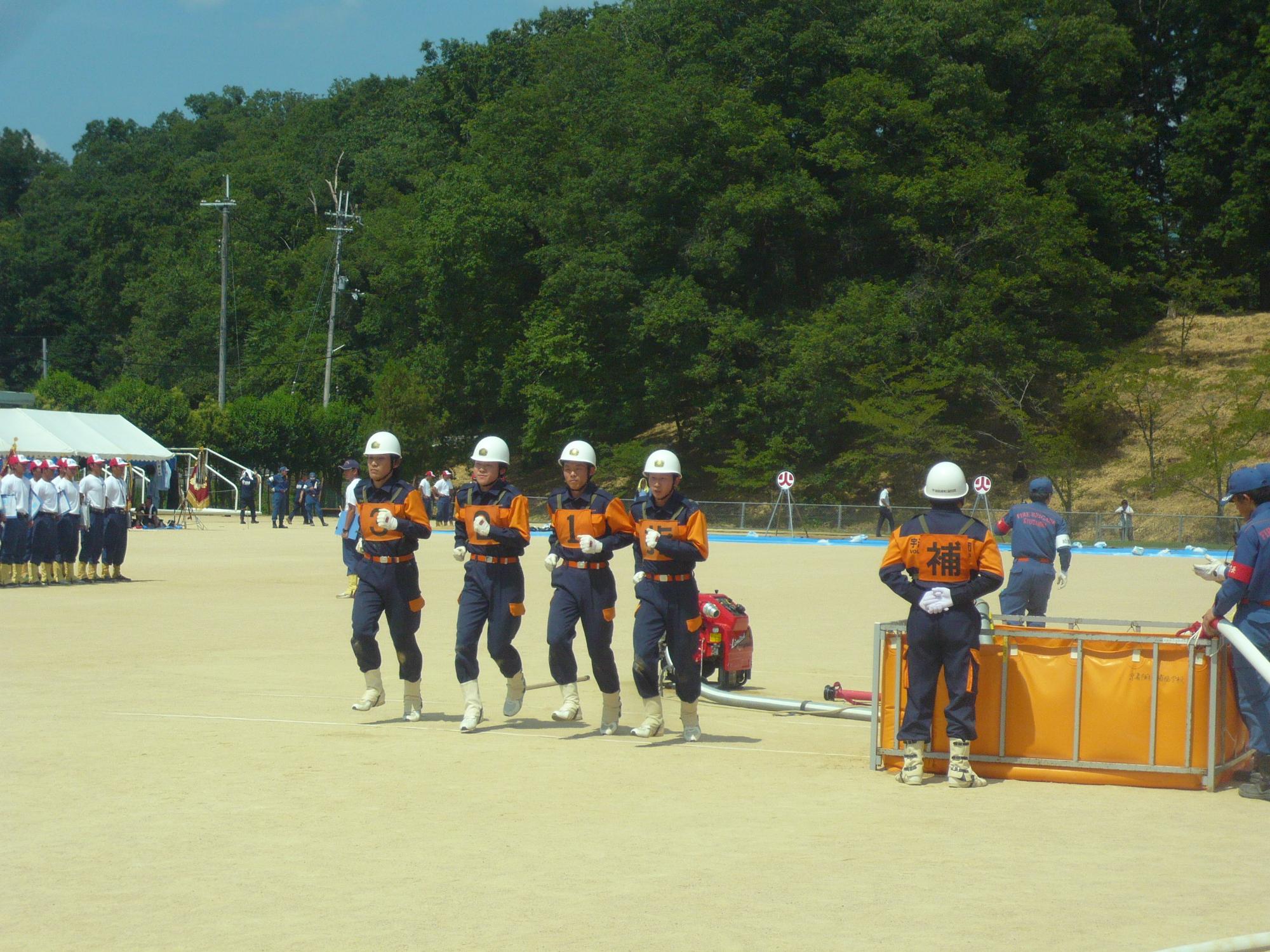 小型ポンプ操法を披露している選手たちの写真