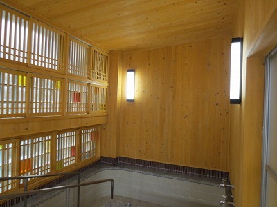 手すりが左側にあり、木のぬくもりが感じる改修後の浴室内の写真