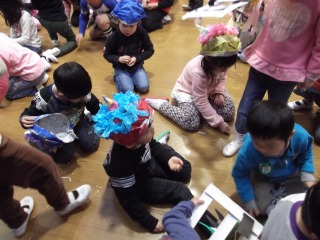 子ども達が床に落ちている豆を見つけて拾っている写真