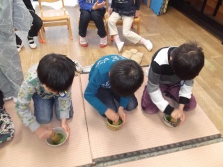 男の子3人が畳の上に並んで座り、お茶をたてているお抹茶教室の写真