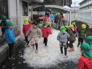 雪山に沢山の子とも達が集まって思い思いに遊んでいる雪遊びの写真
