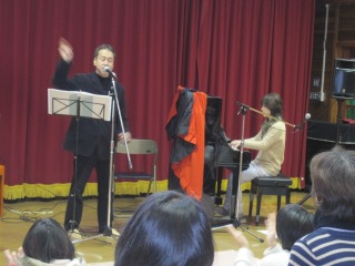 ピアノの伴奏に合わせて、歌を歌っている古川先生の写真
