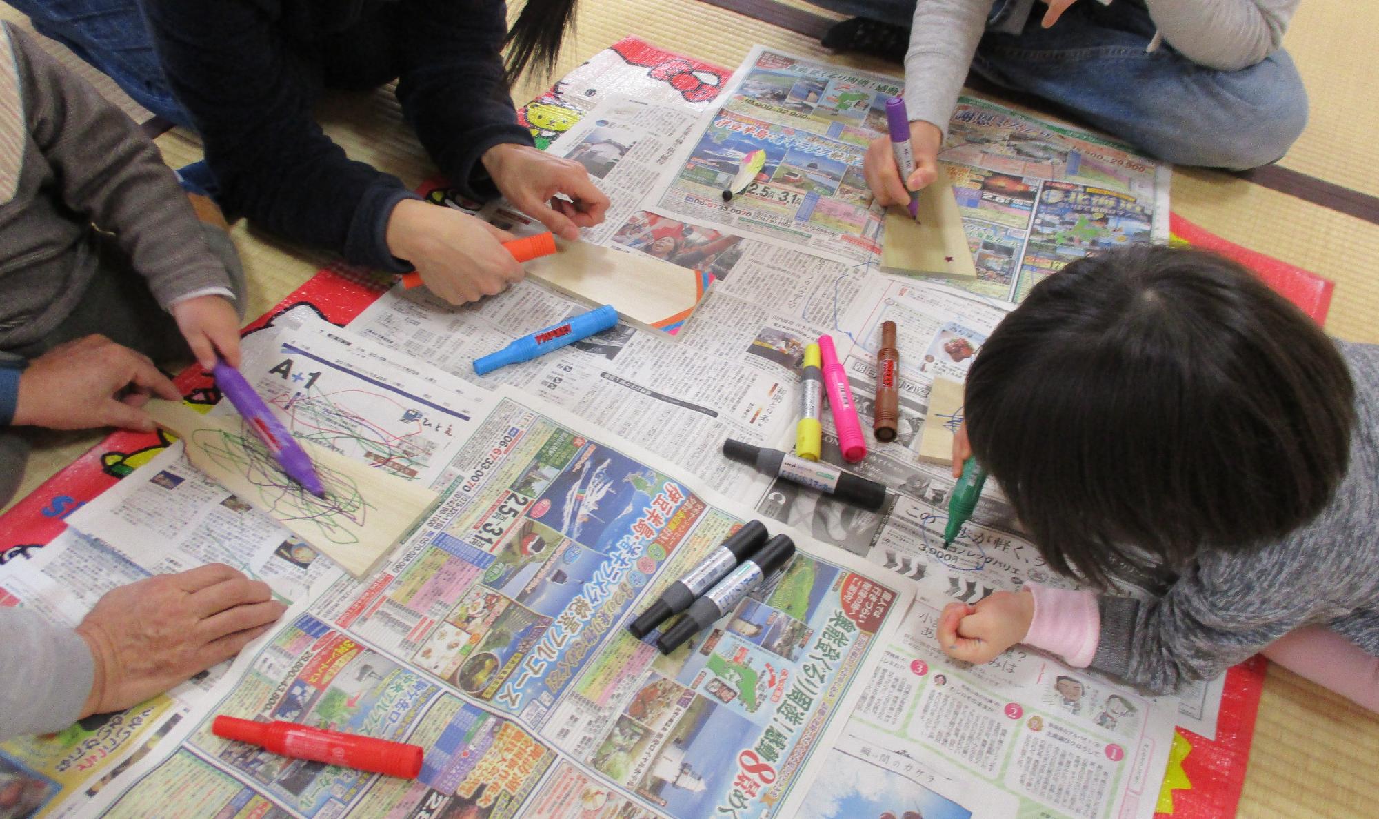 子どもたちが羽子板に絵を描いている写真