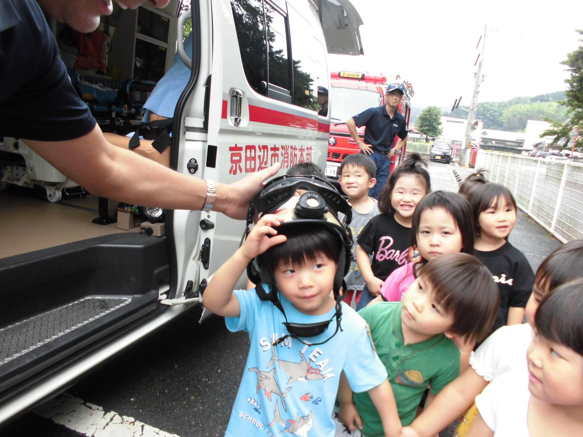 子どもたちが消防車と救急車の車内を見学している様子の写真
