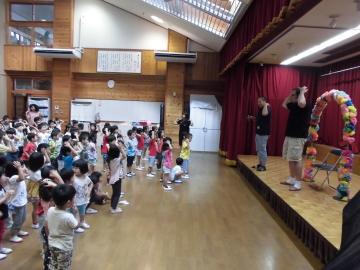 ダニエル先生と子どもたちが英語版の歌遊びを教わっている写真