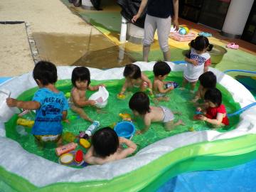 子どもたちが大きなビニールプールの中で遊んでいる様子の写真
