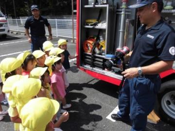 子どもたちがミニ消防車を見せてもらっている様子の写真