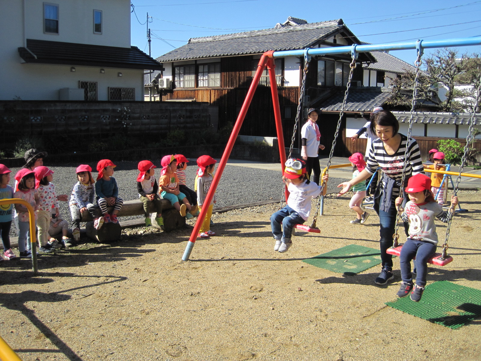 子どもたちが公園のブランコで順番に遊んでいる様子の写真