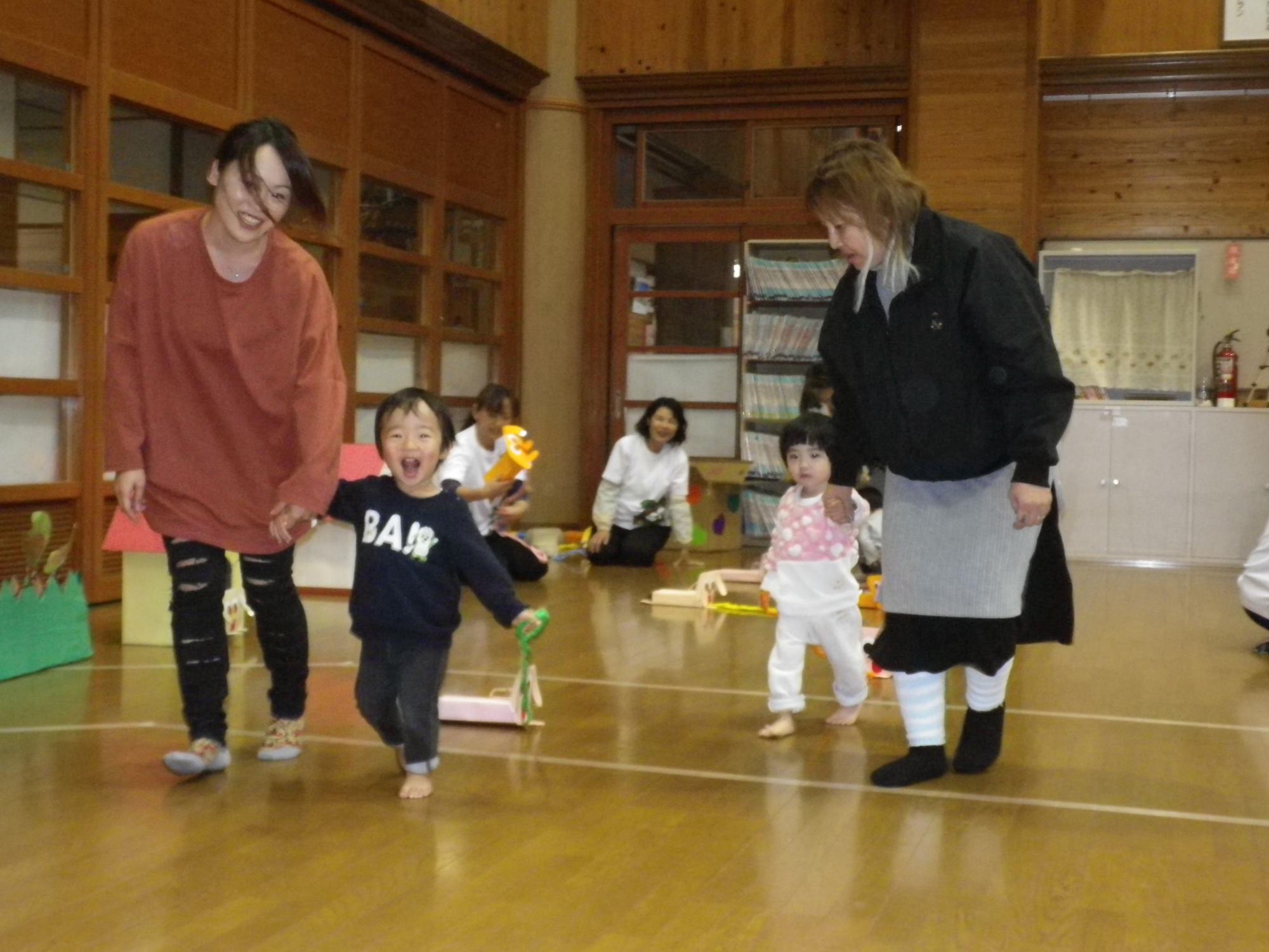 子どもが保護者と一緒に走っている様子の写真