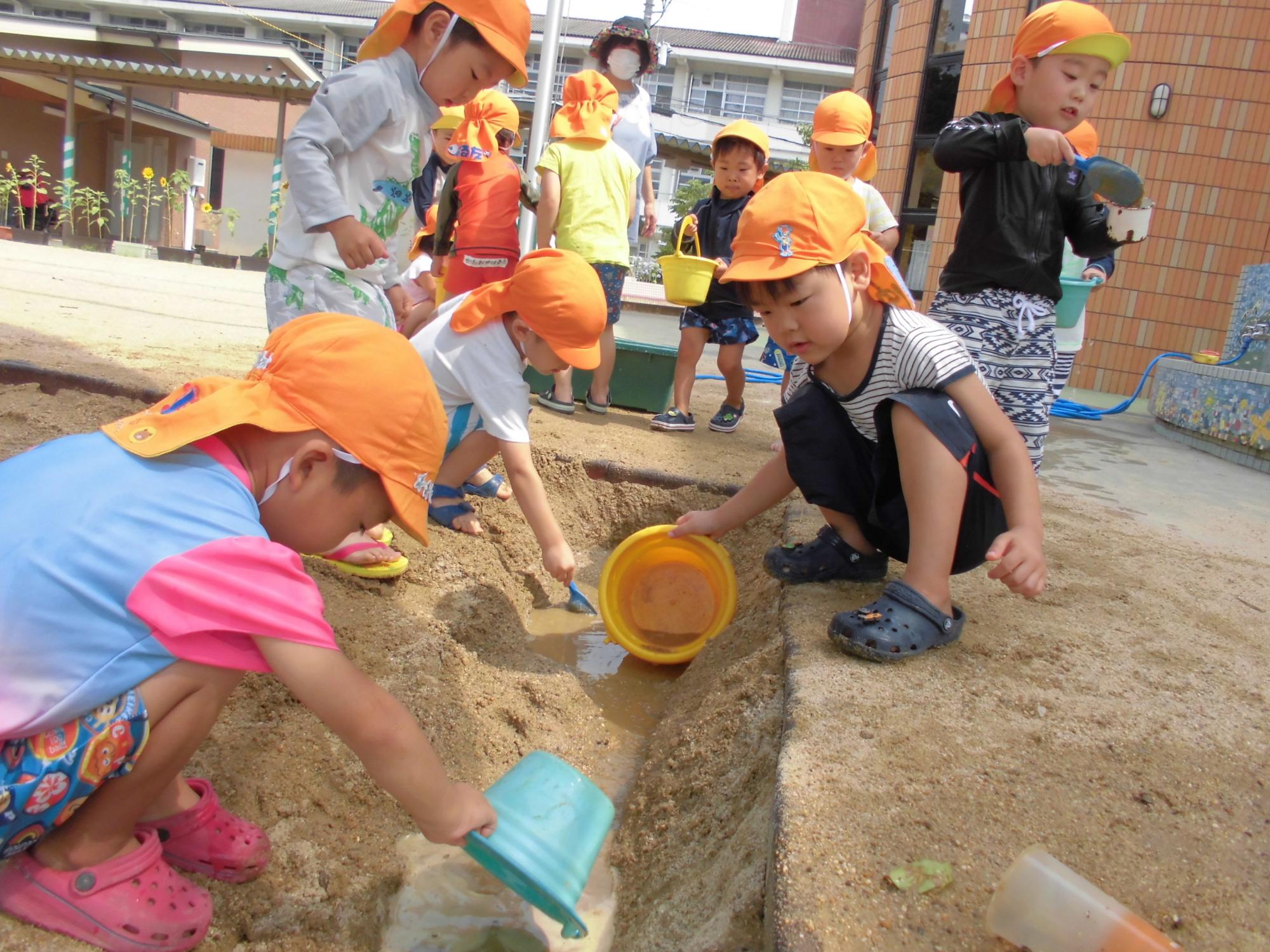 どろんこ遊びをしている子ども達の写真