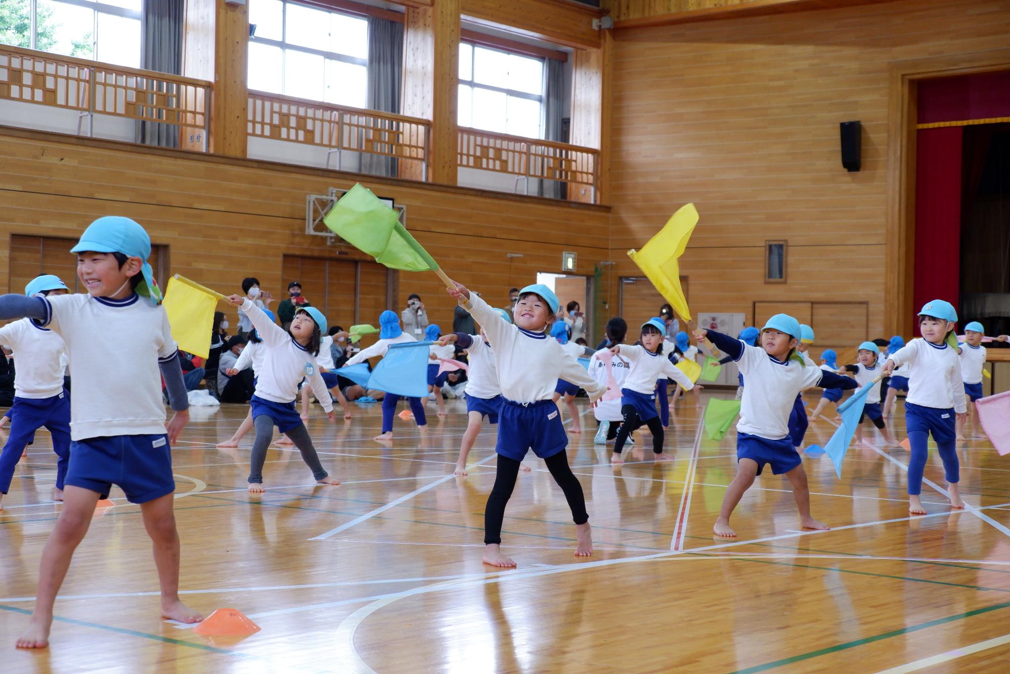 フラッグを使ってダンスを踊る子ども達の写真