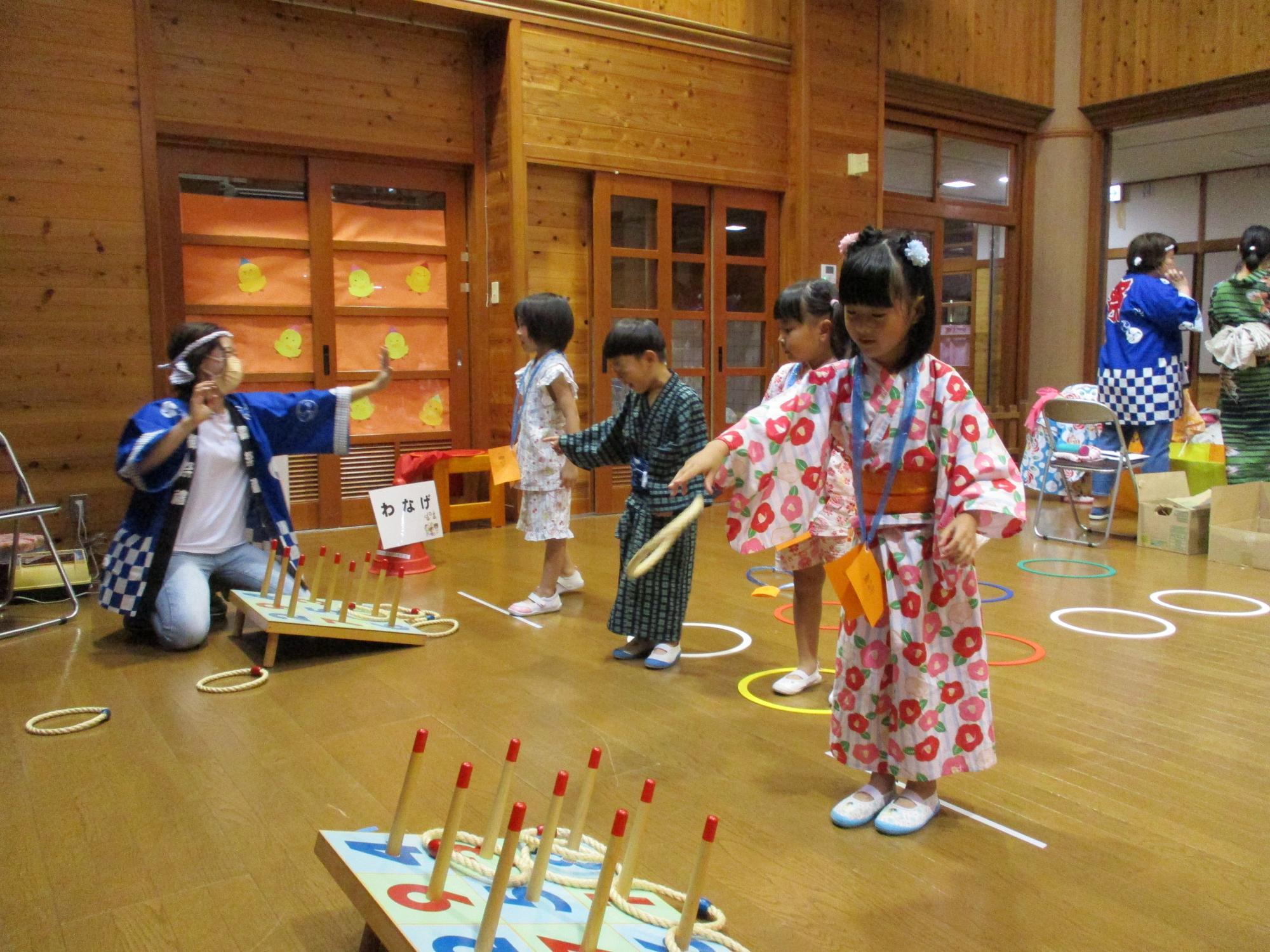 浴衣を着た女の子が輪投げをしている写真