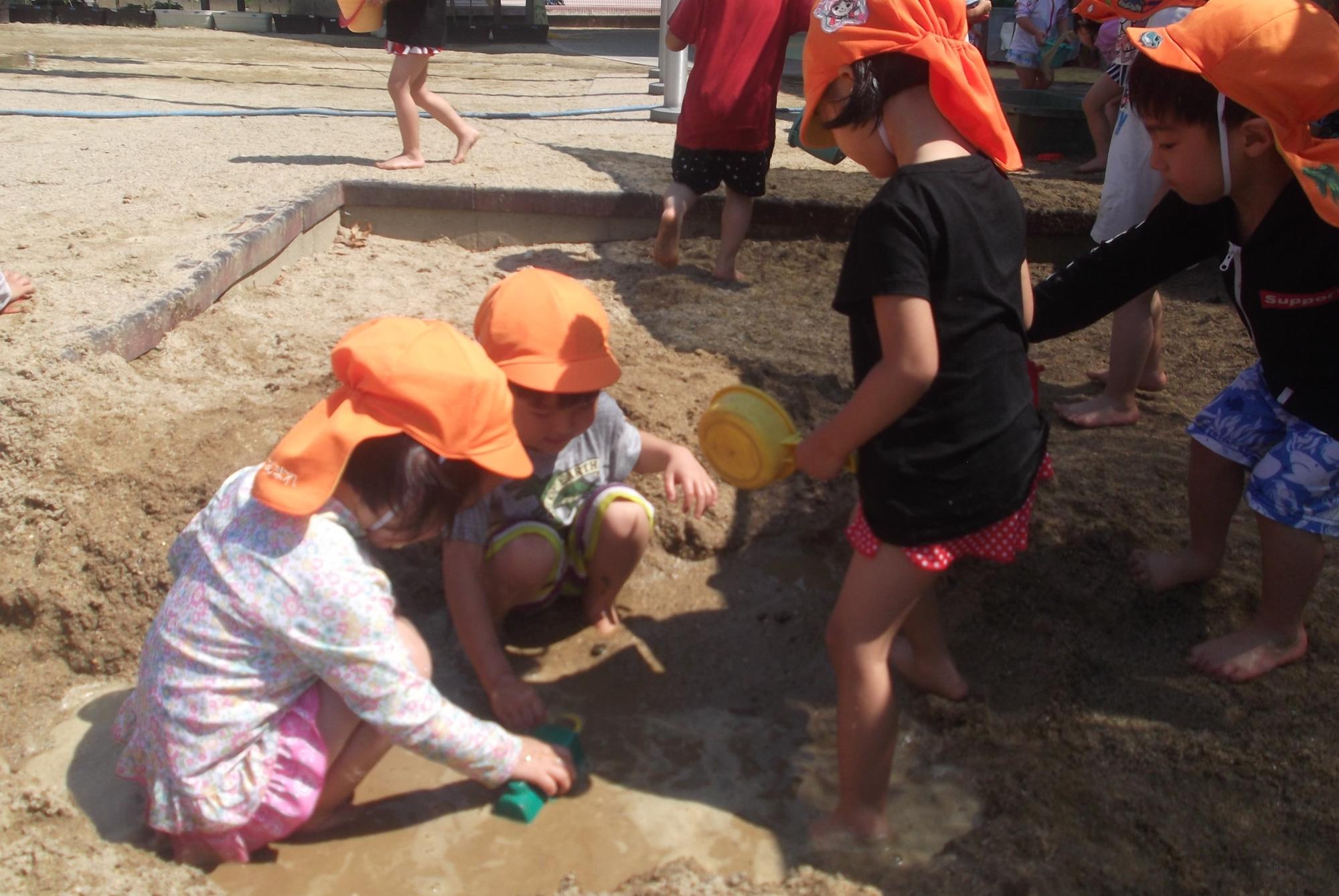 子ども達が泥んこ遊びをしている様子の写真