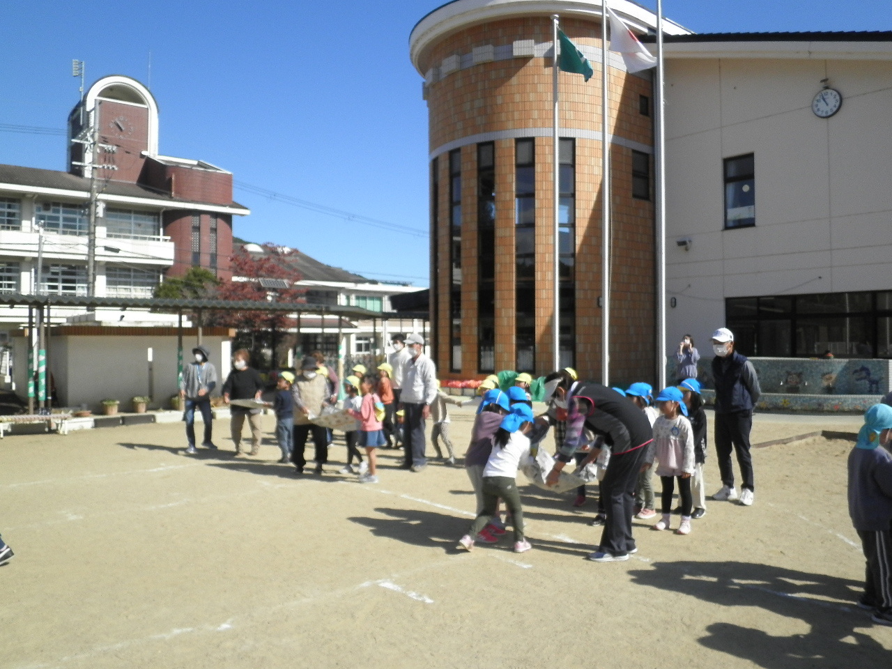 子ども達が老人クラブの方々と一緒にボール運び競争をしている様子の写真
