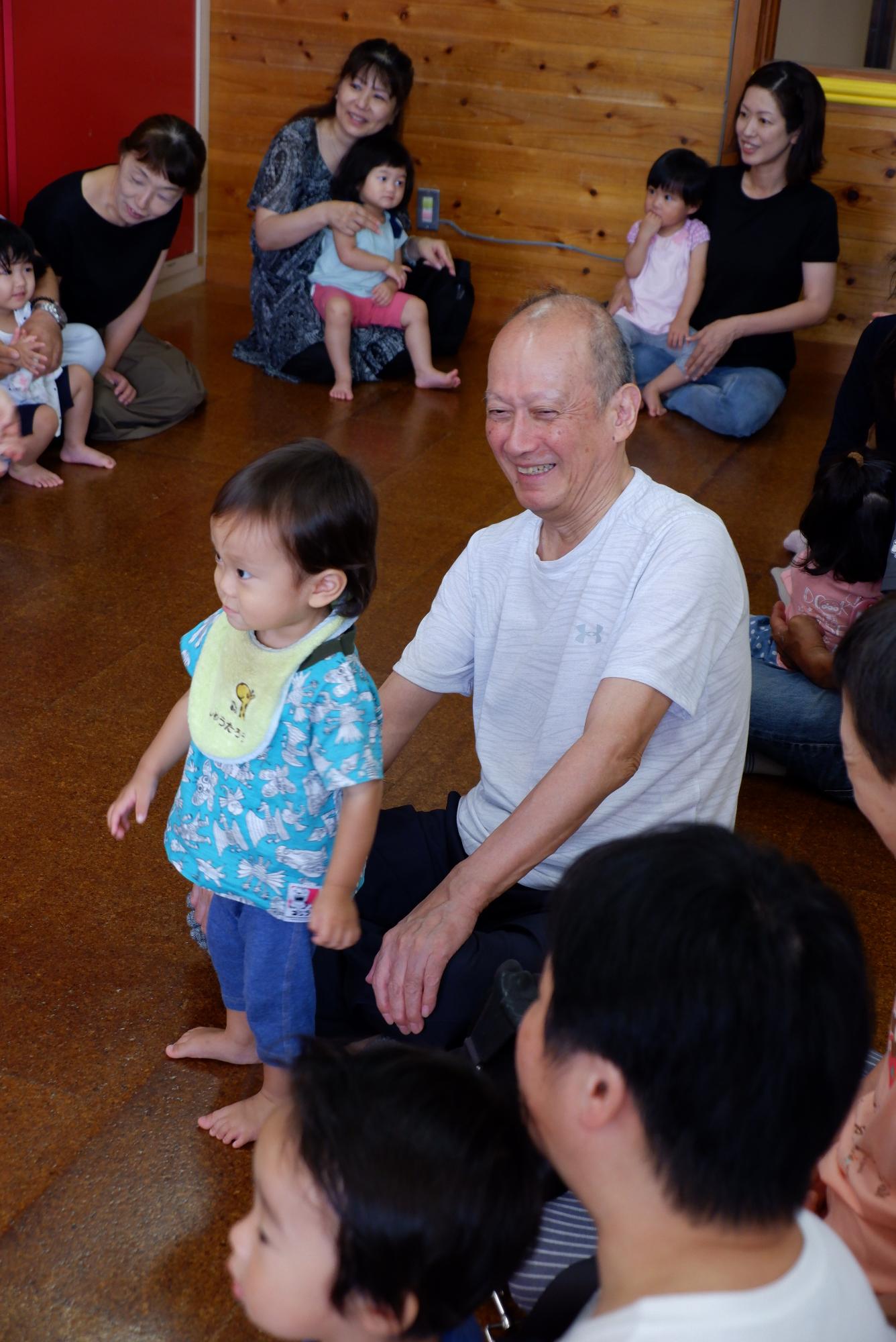 子どもたちが祖父母とふれあい遊びをしている敬老参観の写真