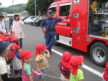 消防者の後部の扉が開いており、子ども達が消防車を見せてもらっている写真