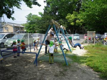 子どもがブランコに乗って遊んでいる写真