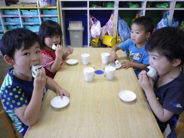 子どもたちが豆おにぎりを食べている写真