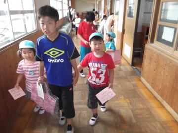 子どもたちが小学生に案内してもらって廊下を歩いている写真