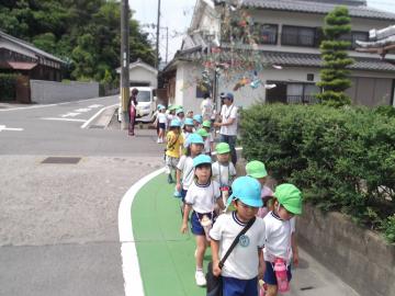 年長組、年中組が並んで歩道を歩き、役場に向かう写真