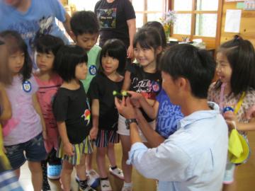 子どもたちが森田哲哉さんに星形のきゅうりを見せてもらっている写真