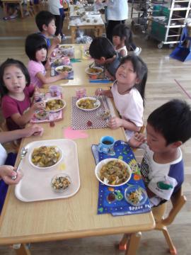 子どもが自分たちの作ったカレーを食べている写真