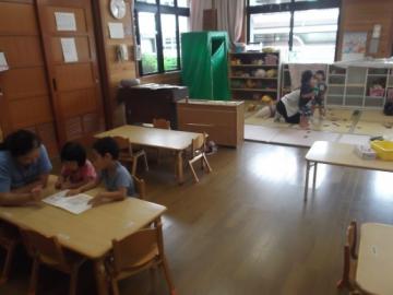 保育ルームで子どもたちが絵本を読んだり、遊んだりしている写真