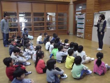 並んで座る園児が注目する中、前方に立ち、話をしている奥朗子先生の写真