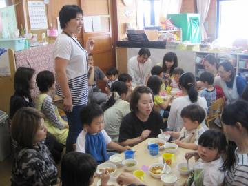 子どもたちがお父さん、お母さんに見守られながら、おいしく食べている様子の給食参観の写真