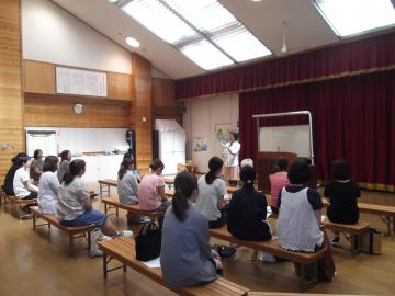 ホールで保護者の方々が赤井登美子先生の講演を聞いている様子の写真