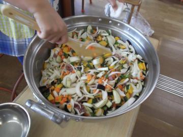 大きな鍋で野菜を炒めている様子の写真