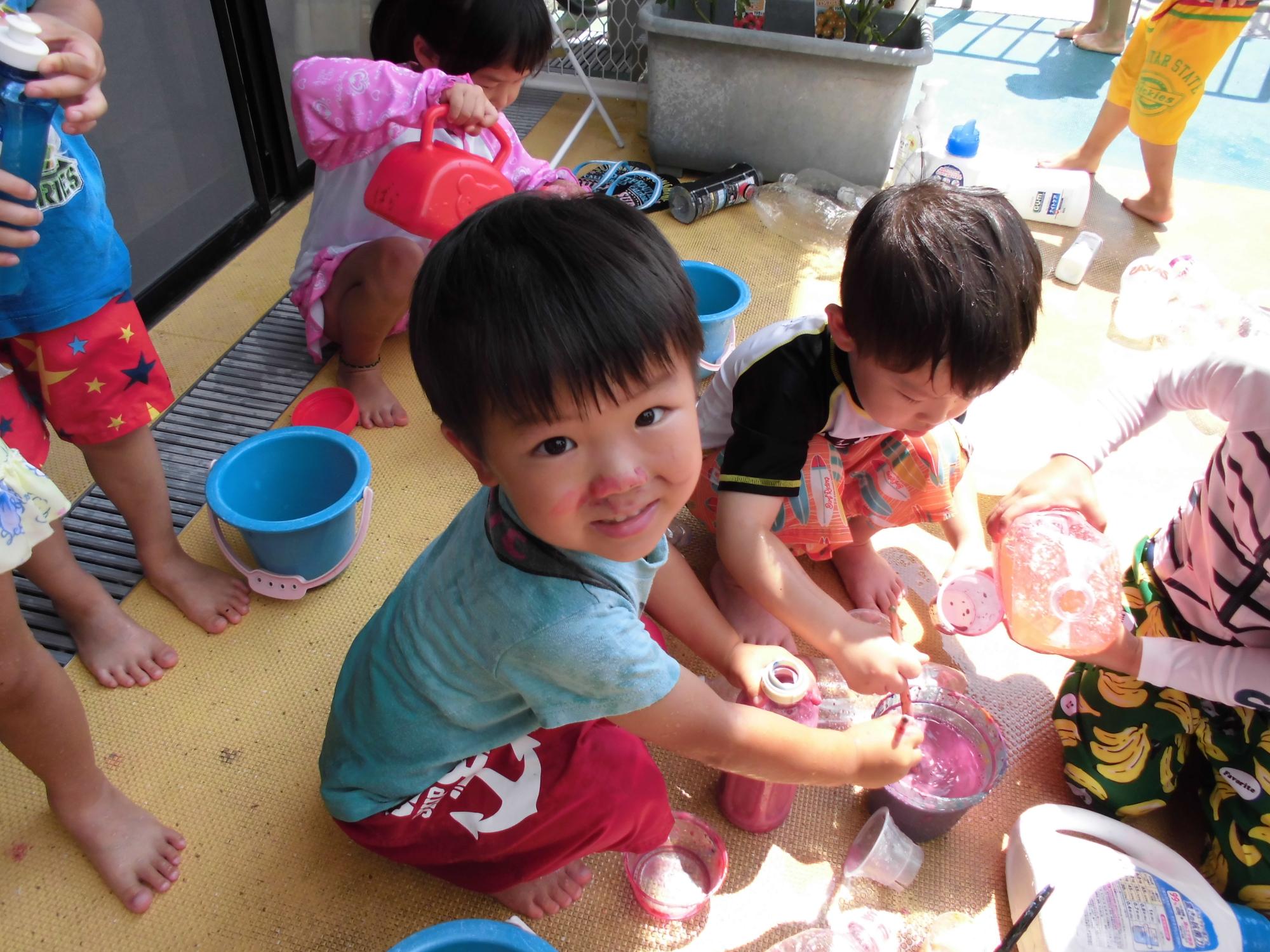 色水遊びをしている幼児らの写真