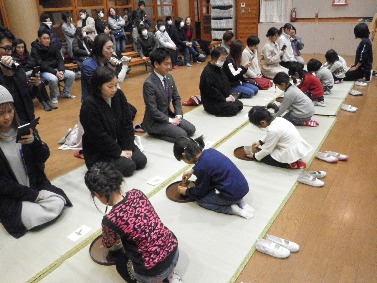 少し緊張した様子でお茶を飲むお母さんたちと子どもたちの写真