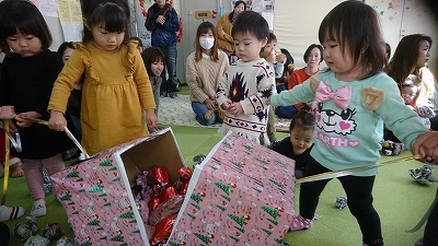 子どもたちが箱を開けるゲームをしている写真