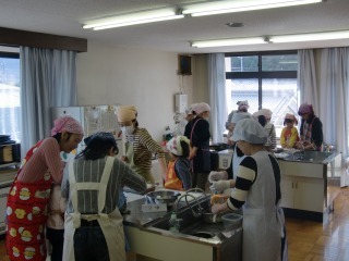 調理室で各調理台に分かれ親子が料理をしている写真