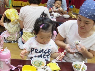 ママと子供たちが出来上がったお味噌汁を食べている写真