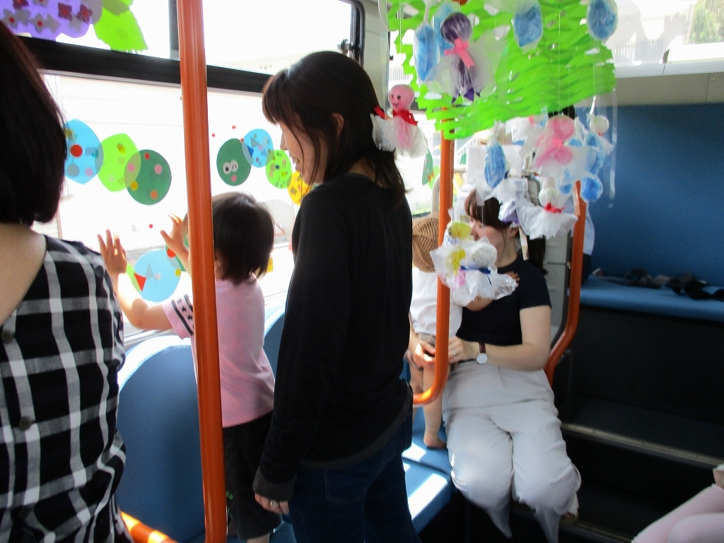 親子でバスに飾り付けをしている様子の写真