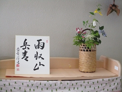 飾られた茶花と掛軸の写真