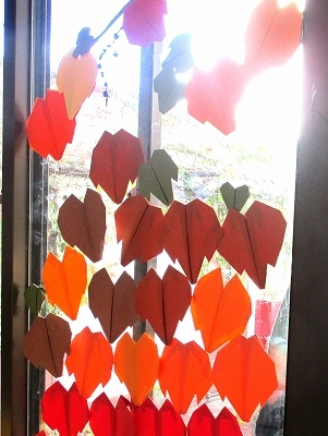 センターの窓に赤い色紙で作った葉っぱを飾った様子の写真