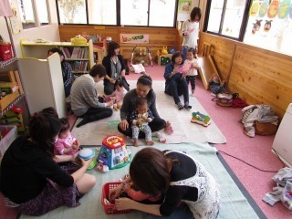 プレイマットの上にあるおもちゃなどで参加した親子が遊んでいる写真
