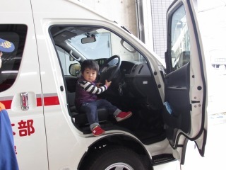 救急車の運転席に乗っている子どもの写真