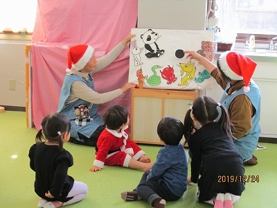 子どもたちがパンダやきつねなどのイラストが描かれパネルシアターを楽しんでいる様子の写真