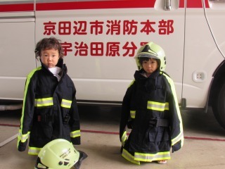 2人の子供がキッズ消防隊の服を着ている写真