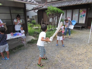 男の子たちが向かい合って剣のアートバルーンで遊んでいる写真